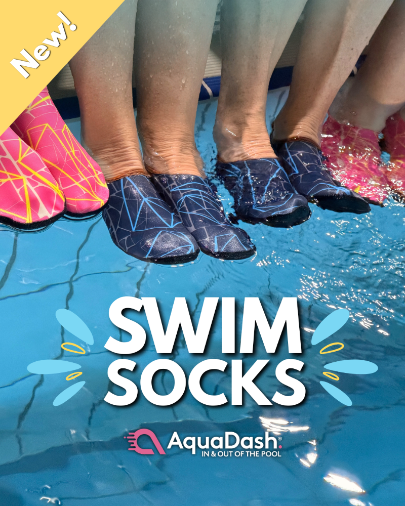Several people standing in a swimming pool wearing AquaDash swim socks. The socks are dark blue with a light blue geometric line pattern.